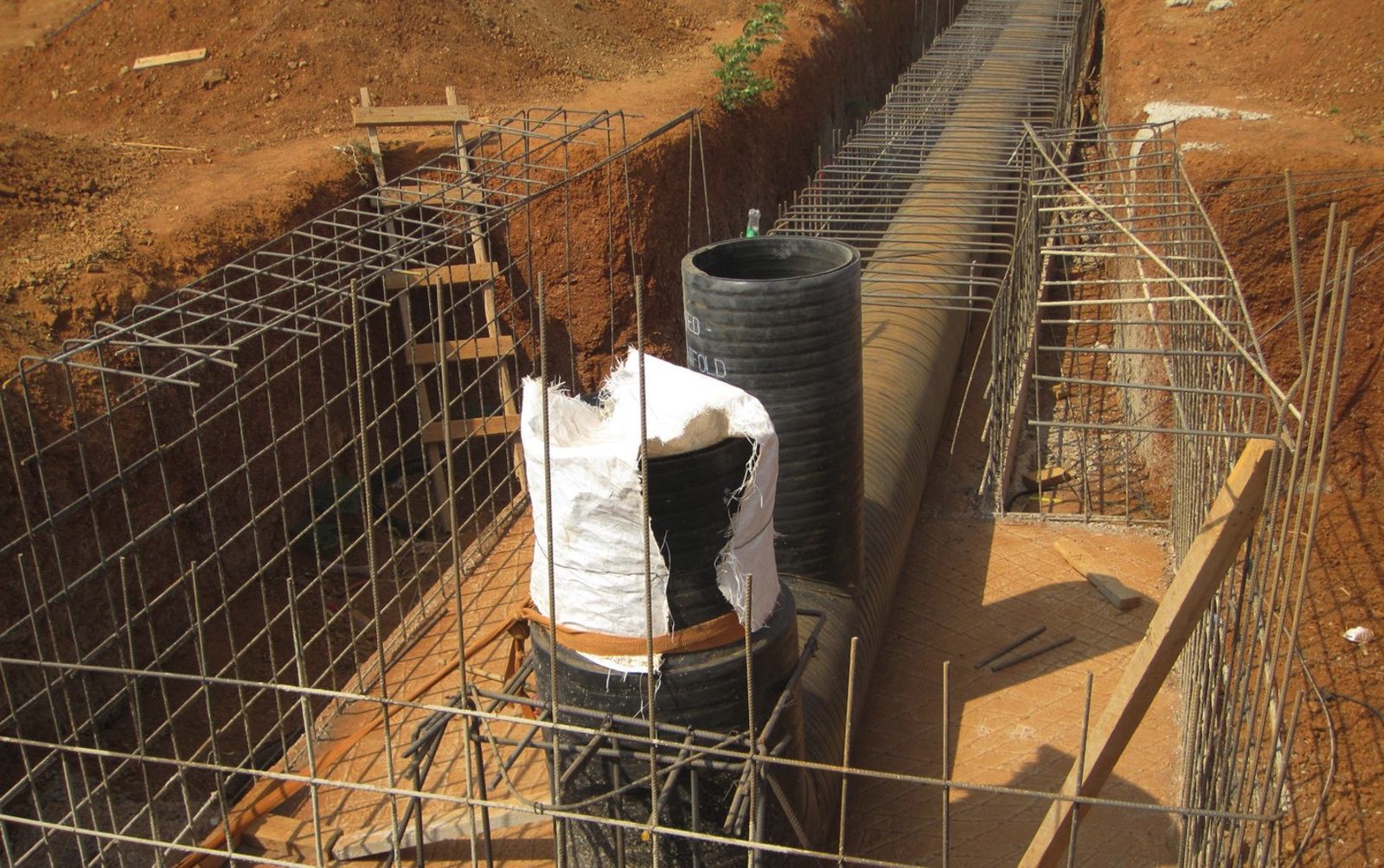 Reinforcement cages and a vertical pipe riser set in a deep excavated trench